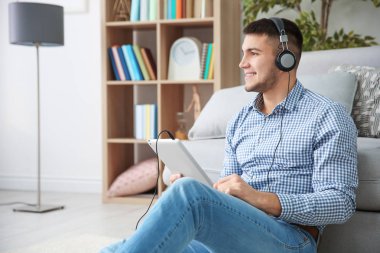 Sesli kitapta kulaklık evde dinlerken adam