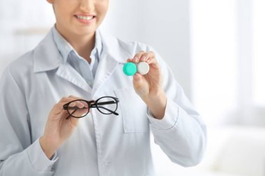 Kadın doktor tutan Kontakt lens case ve gözlük, portre