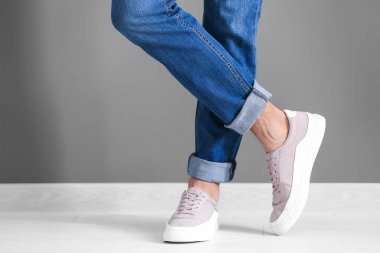 Adam gri duvarının yakınında rahat ayakkabı