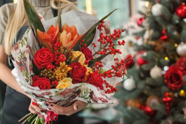 Güzel buket çiçek dükkanında tutan kadın çiçekçi
