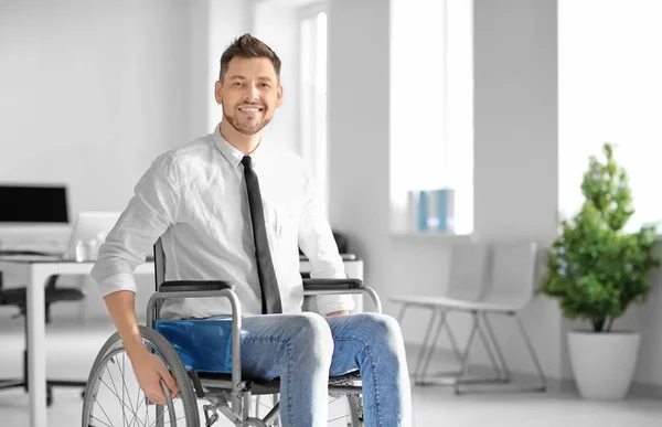 Junger Mann im Rollstuhl am Arbeitsplatz — Stockfoto