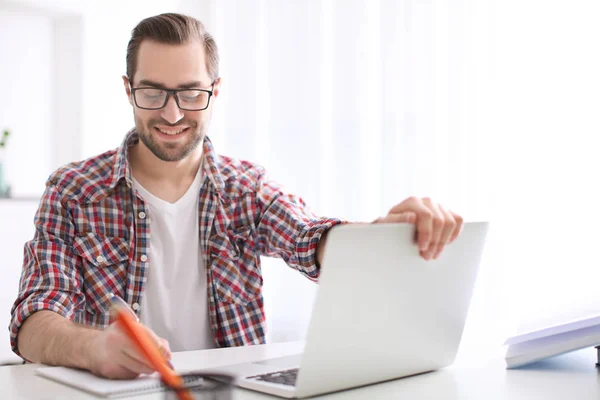 Studente con computer portatile che studia a tavola al chiuso — Foto Stock