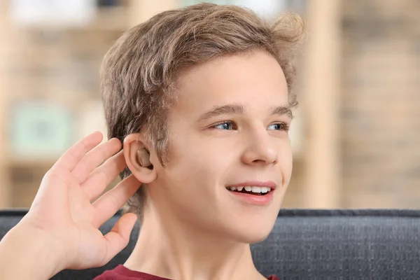 Хлопчик-підліток з слуховим апаратом у приміщенні — стокове фото
