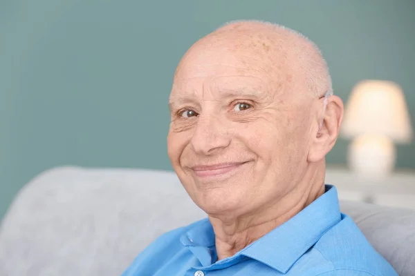 Старший чоловік з слуховим апаратом у приміщенні — стокове фото