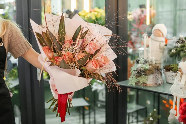 Floristería femenina sosteniendo hermoso ramo en la tienda de flores — Foto de Stock