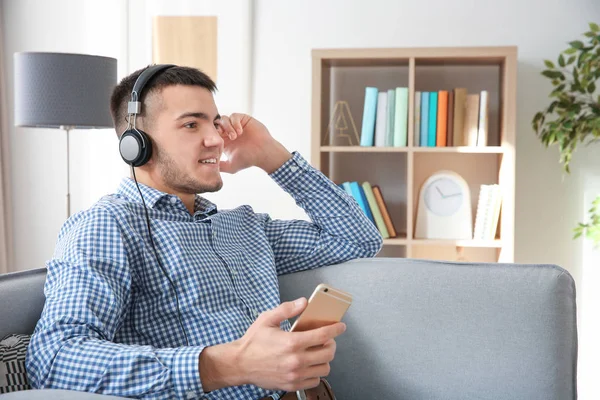 Άνθρωπος Ακούει Audiobook Μέσω Ακουστικών Στο Σπίτι — Φωτογραφία Αρχείου