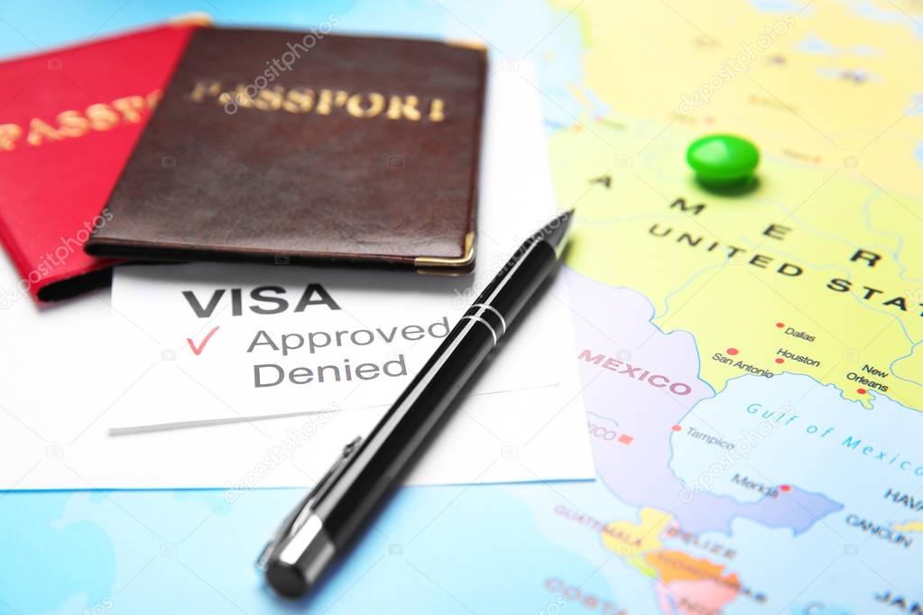 Passports and pen on map. Approved American visa