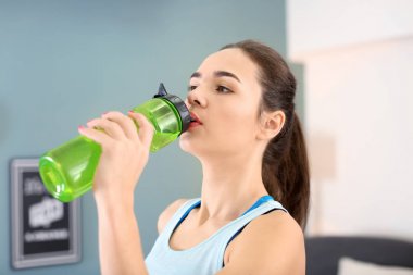 Fitness egzersizleri evde yaptıktan sonra güzel ve genç birbayan içme suyu