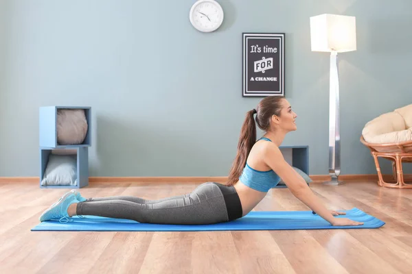 Hermosa joven haciendo ejercicio de fitness en casa —  Fotos de Stock