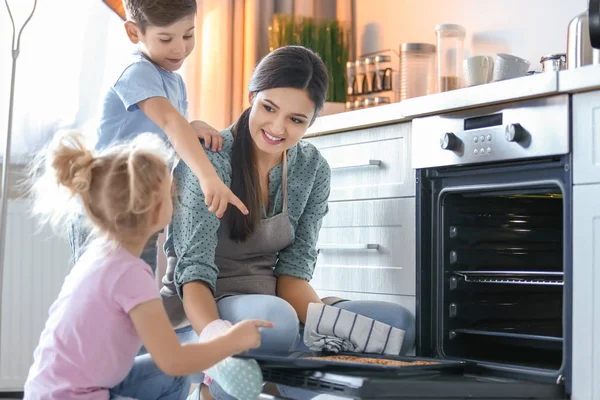 Kvinna att behandla barn till cookies inomhus. Färskt från ugnen — Stockfoto