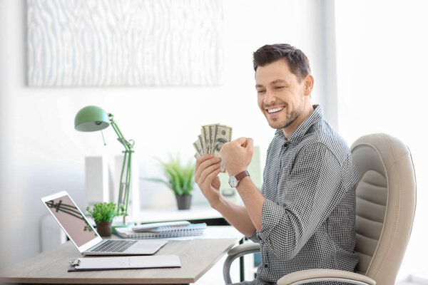 Happy financial trader with money at table in office. Forex concept