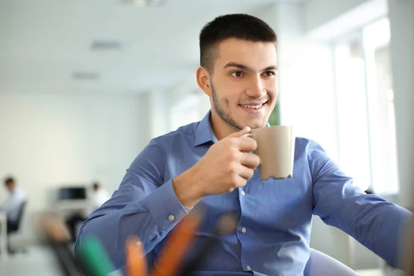 Junger Mann Trinkt Kaffee Während Büro Arbeitet — Stockfoto