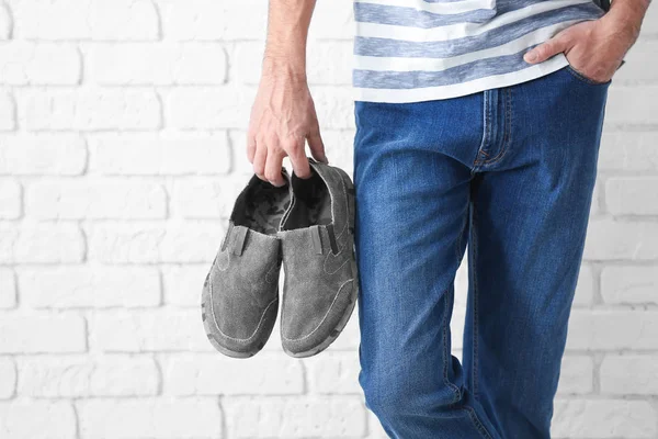 Homem Segurando Sapatos Fundo Parede Tijolo — Fotografia de Stock