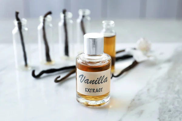 Glass bottle with vanilla extract on table