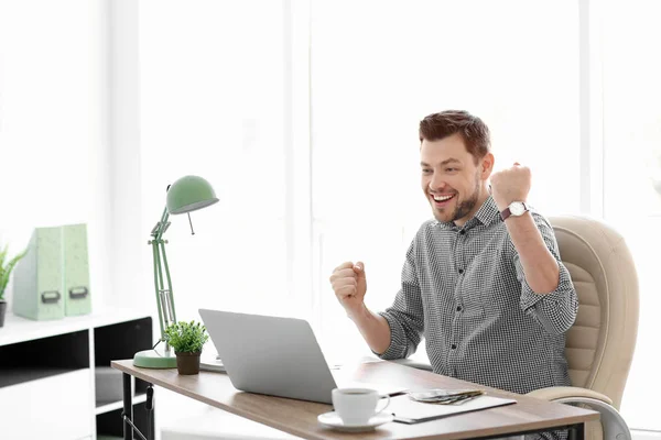 Glad affärsman vid bord i office — Stockfoto