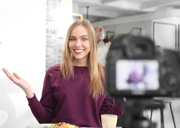 Female blogger recording video in cafe