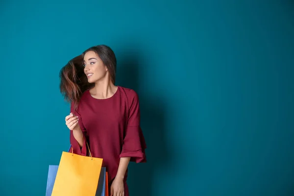 美しい若いです女性でショッピングバッグ上の色背景 — ストック写真