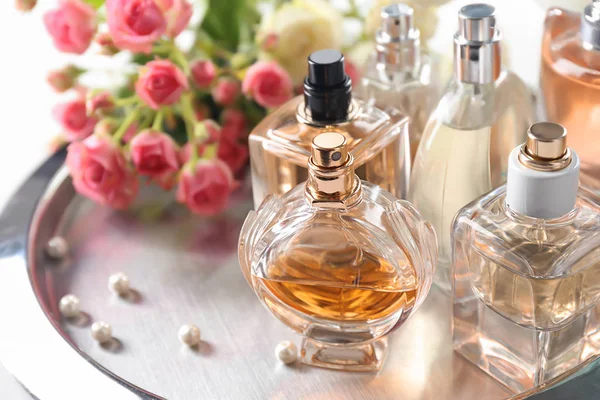 Bandeja de metal con frascos de perfume sobre mesa —  Fotos de Stock