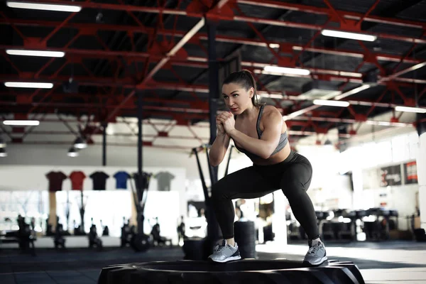 Ung muskulös kvinna utbildning på tunga däck i gymmet — Stockfoto