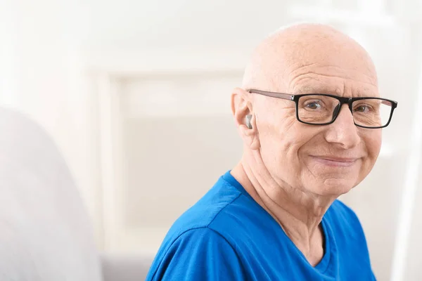 Uomo anziano con apparecchi acustici al chiuso — Foto Stock