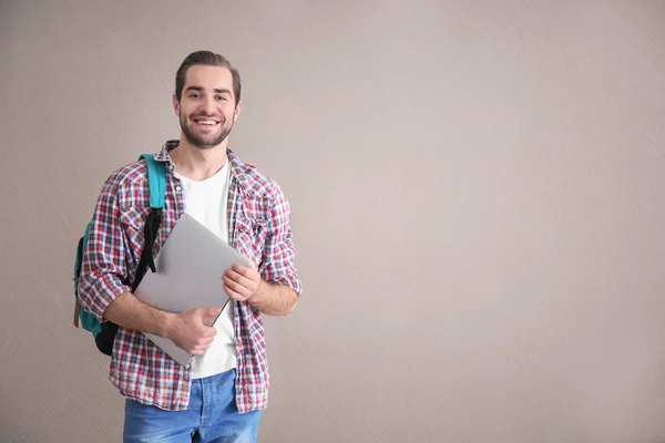 Student med laptop på färg bakgrunden — Stockfoto