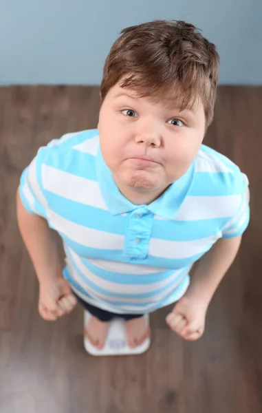 Overgewicht jongen staande op vloer weegschalen binnenshuis — Stockfoto