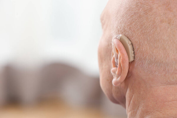 Старший мужчина со слуховым аппаратом внутри
