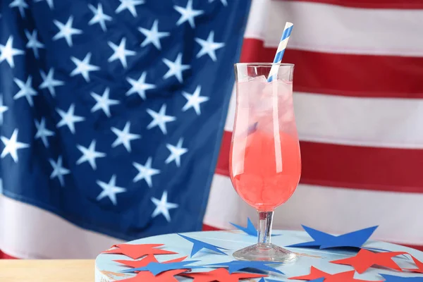 Glas mit Alkoholcocktail auf Tisch gegen amerikanische Flagge — Stockfoto