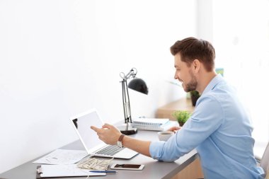 Ofiste çalışan laptoplu bir iş adamı.