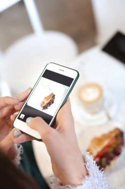 Genç kadın alarak fotoğraf cep telefonu kafede, closeup ile lezzetli yemekler