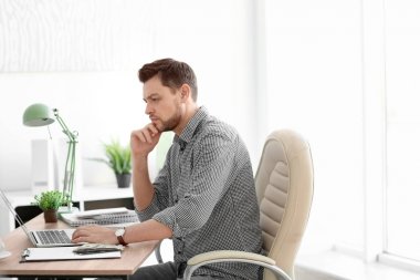 Ofiste çalışan laptoplu bir iş adamı.