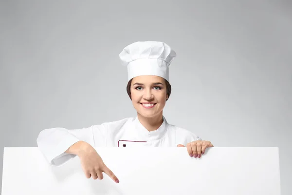 Retrato Chef Feminino Com Cartaz Vazio Sobre Fundo Cinza — Fotografia de Stock