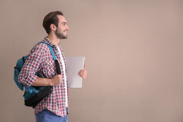 Estudiante con portátil sobre fondo de color — Foto de Stock