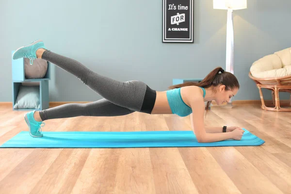 Mulher bonita fazendo exercício de fitness em casa — Fotografia de Stock