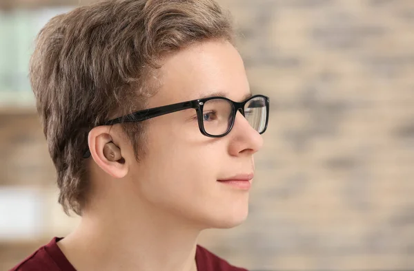 Adolescente ragazzo con apparecchio acustico al chiuso — Foto Stock