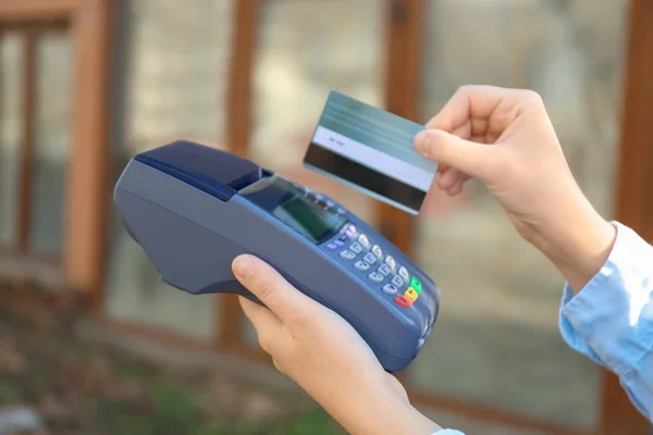 Mujer usando terminal bancaria para pago con tarjeta de crédito al aire libre —  Fotos de Stock