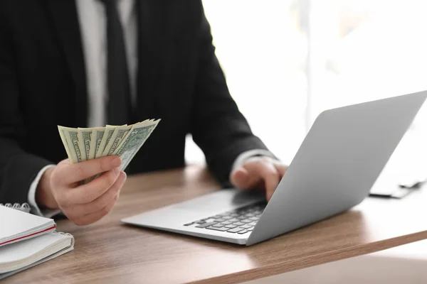 Commerciante finanziario con laptop e denaro che lavora in ufficio. Concetto Forex — Foto Stock