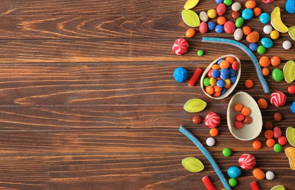 Colorful candies on wooden background, flat lay — Stock Photo, Image