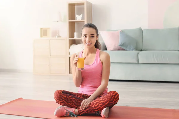 Beautiful sporty woman with glass of juice at home — Stock Photo, Image