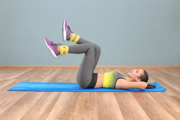 Beautiful young woman doing fitness exercise at home — Stock Photo, Image