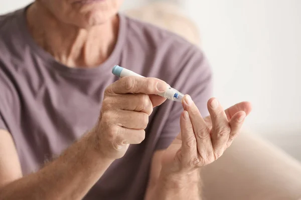 Paciente de edad avanzada con diabetes que mide el nivel de azúcar en sangre en el hogar, primer plano — Foto de Stock