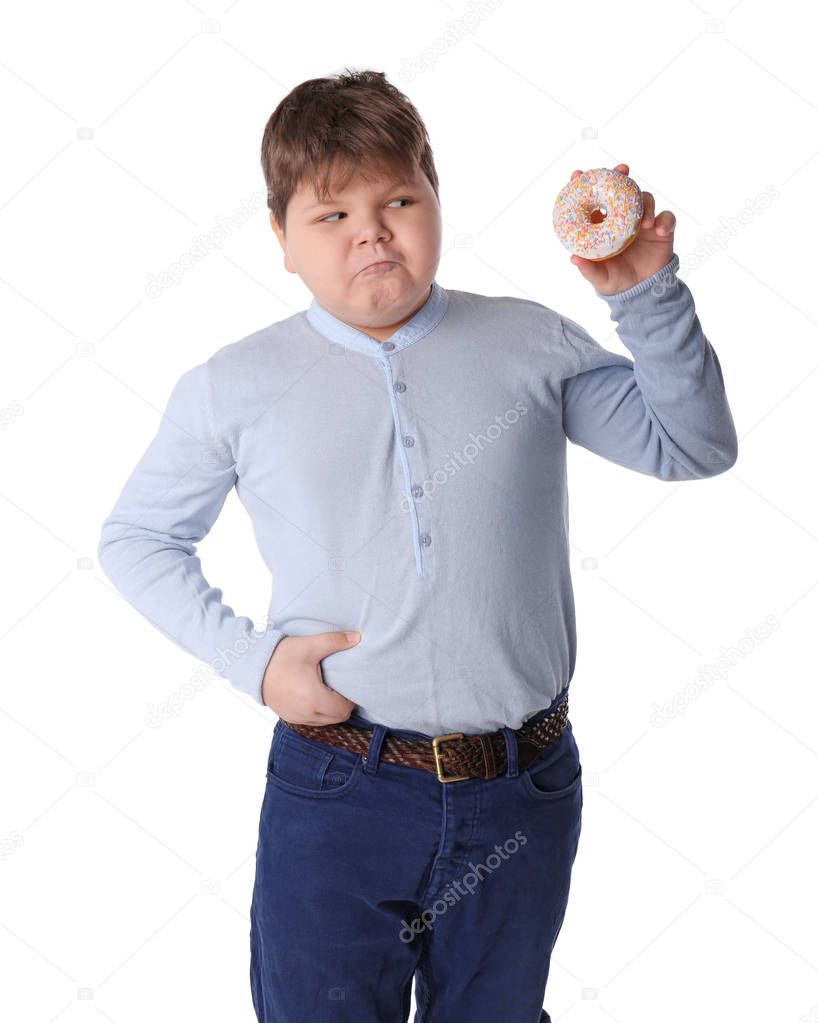 Overweight boy with doughnut on white background
