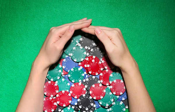 Vrouw met casino chips aan groene tafel — Stockfoto