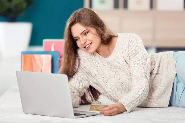 Jovem mulher compras online com cartão de crédito e laptop no chão — Fotografia de Stock