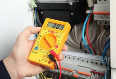 Genç elektrikçi dağıtım panosu, closeup gerilim ölçme