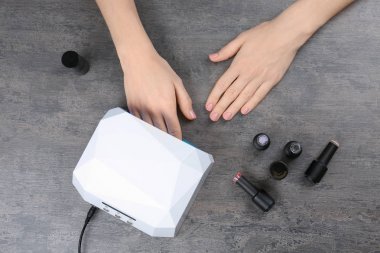 Masada manikür için UV lamba kullanan kadın