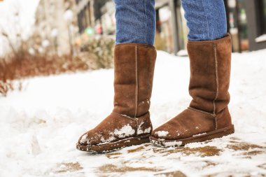 Kışın caddenin üzerinde sıcak ayakkabı giymiş şık kadın