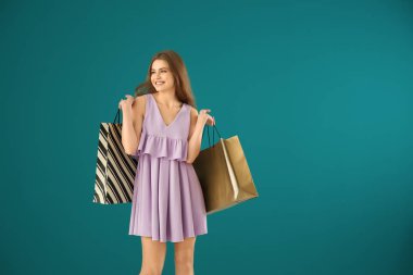 Arkaplanda alışveriş torbaları olan güzel genç bir kadın.