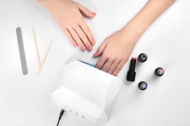 Masada manikür için UV lamba kullanan kadın