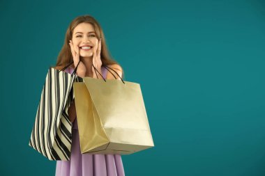 Arkaplanda alışveriş torbaları olan güzel genç bir kadın.